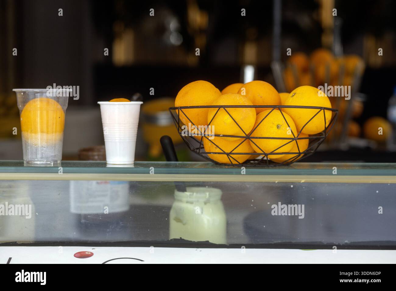 A basket of oranges and some cups on a counter in Rhodes. Stock Photo