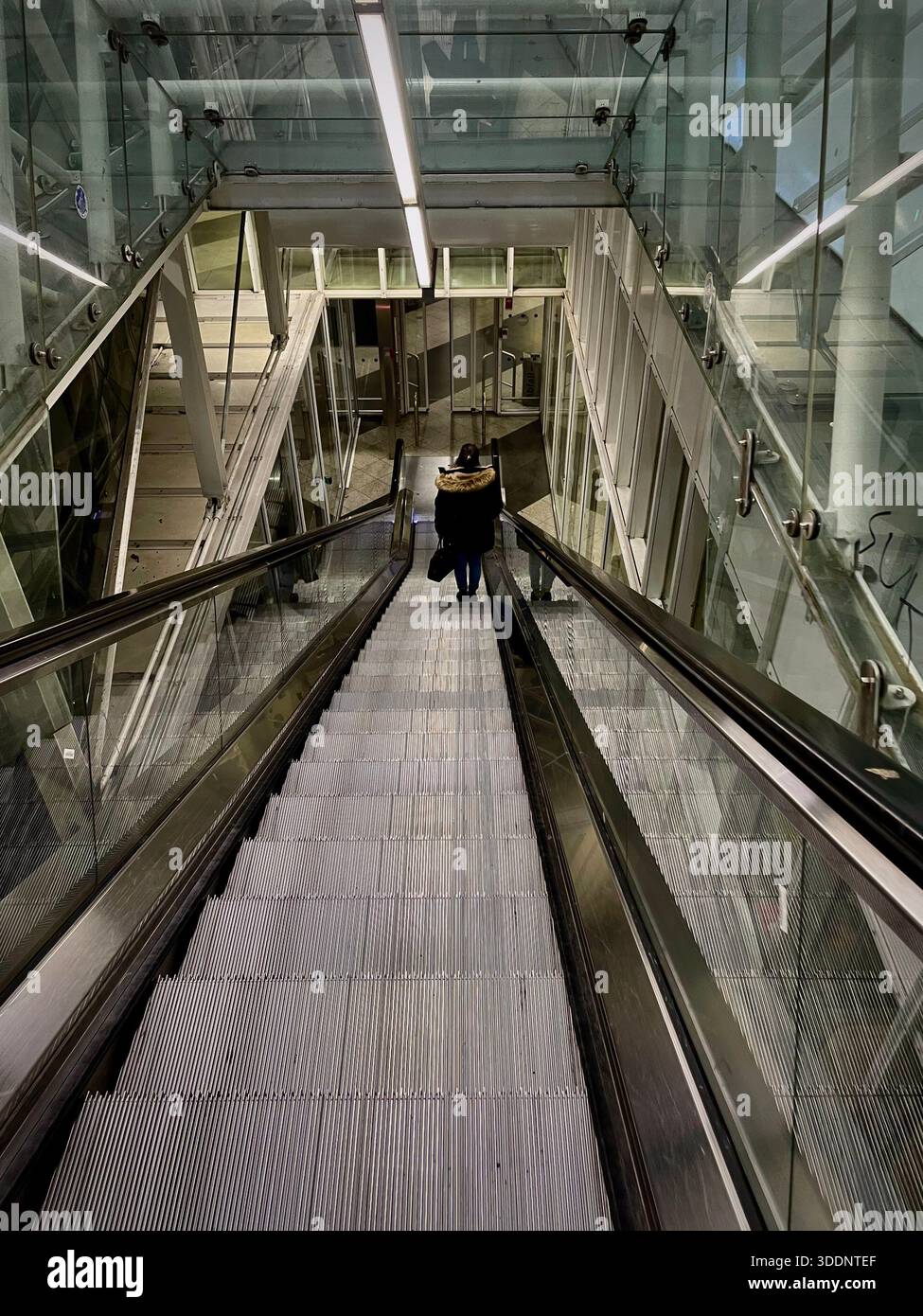 Person descending escalator in modern airport interior - Smartphone Captured Stock Image