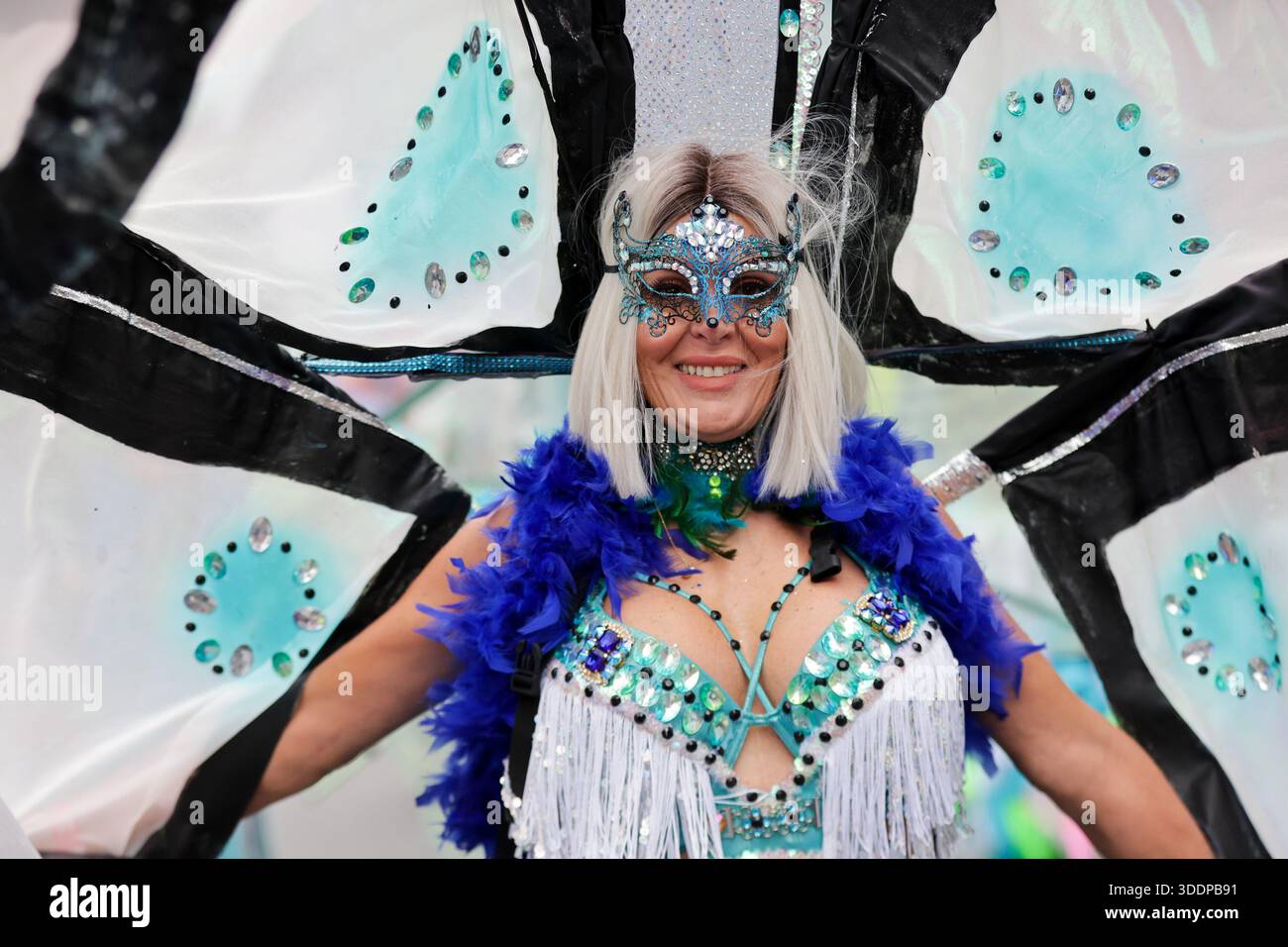 A performer wearing a face mask and coloured outfit takes part in the ...