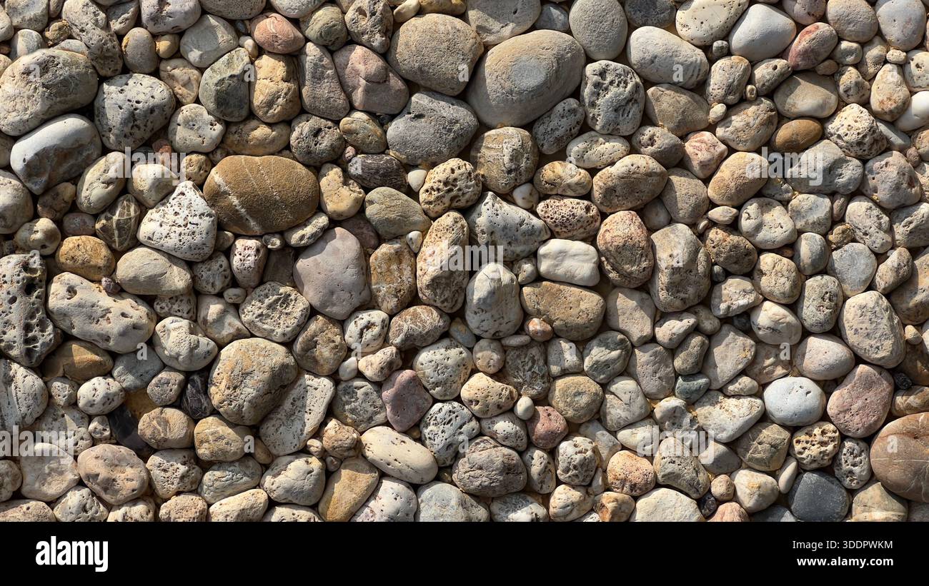 Assorted pebbles and small stones creating a natural texture background Stock Photo