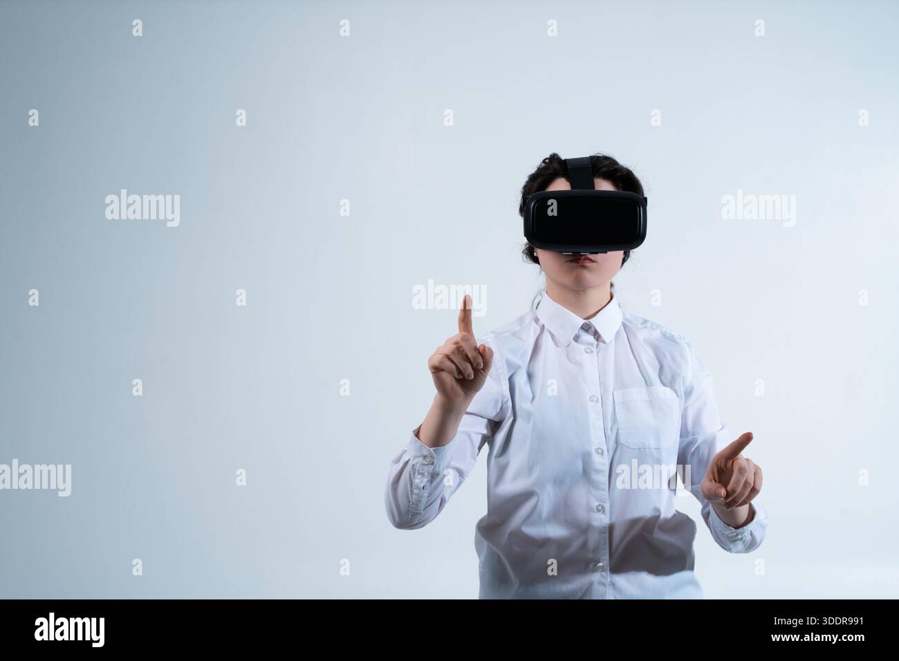 Woman wearing virtual reality headset and selecting digital elements with finger using futuristic human computer interaction technology Stock Photo