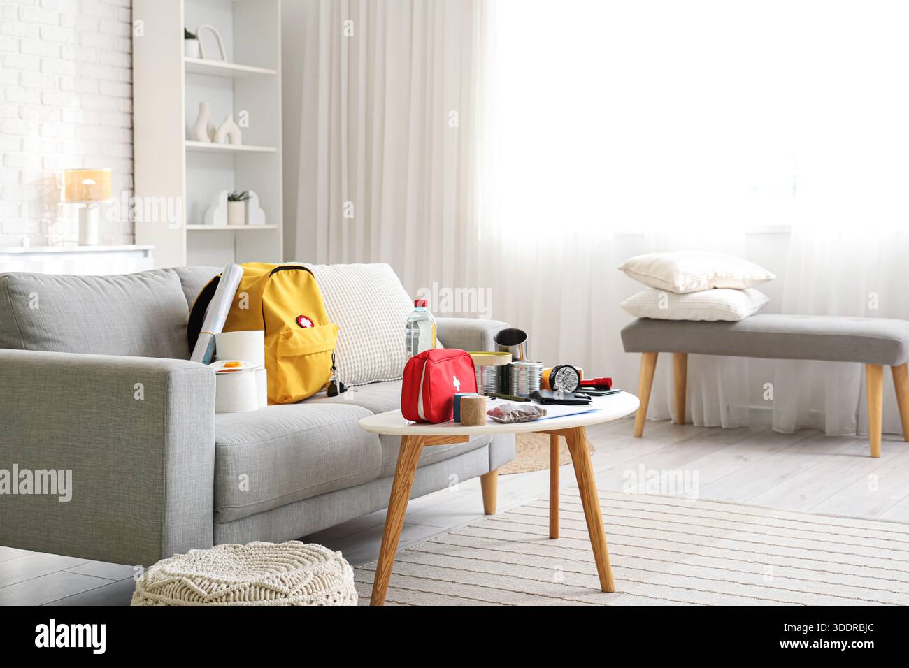 Emergency backpack with necessities on table in living room interior Stock Photo