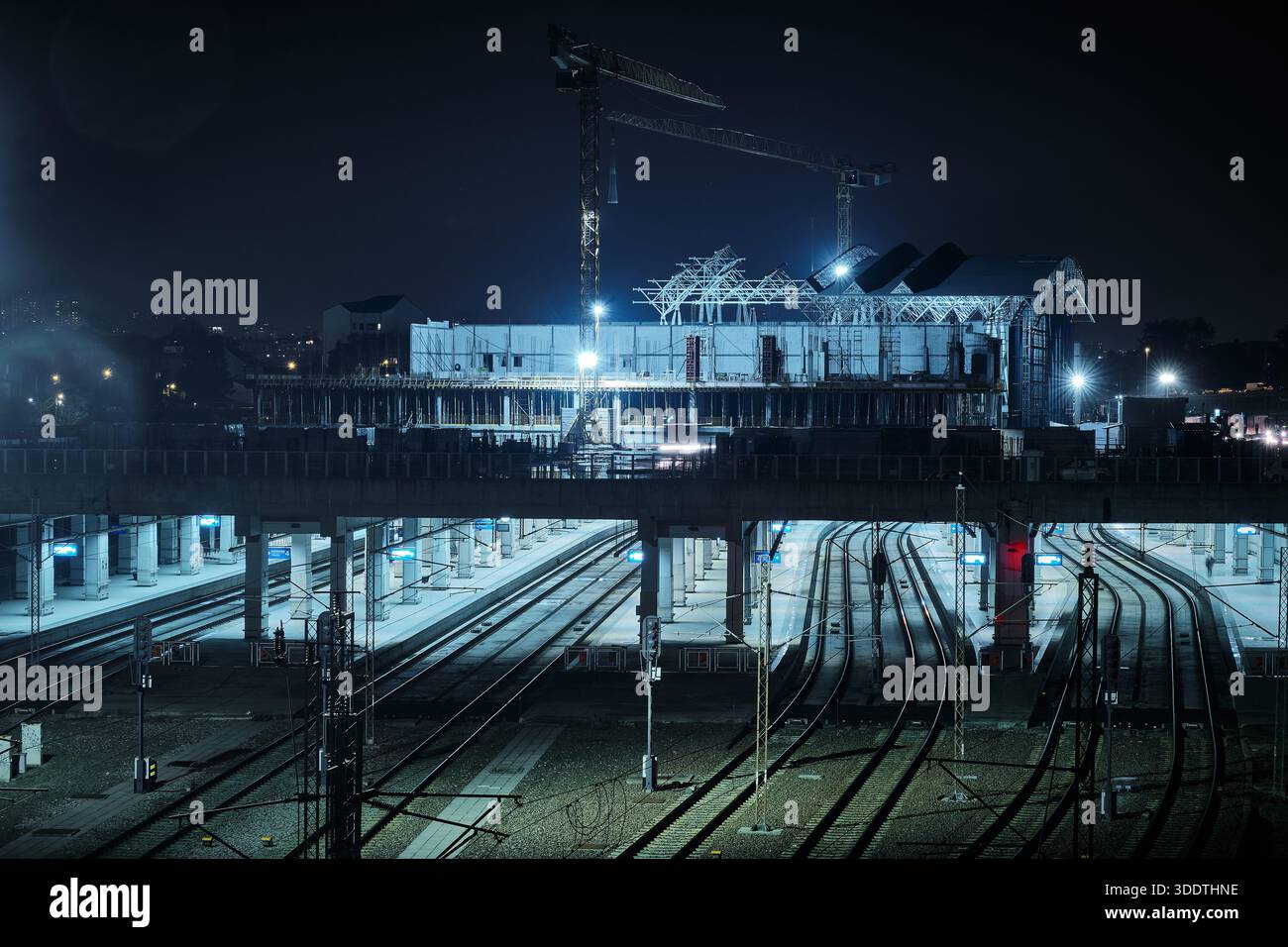 Nighttime view of railway construction site with multiple train tracks ...
