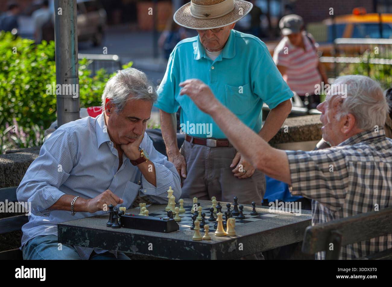 A lively game of street chess unfolds in a New York City park. Stock Photo