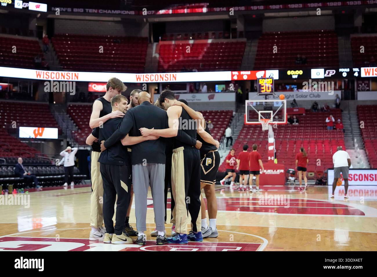 Purdue players and coaches huddle during warmups before an NCAA college ...