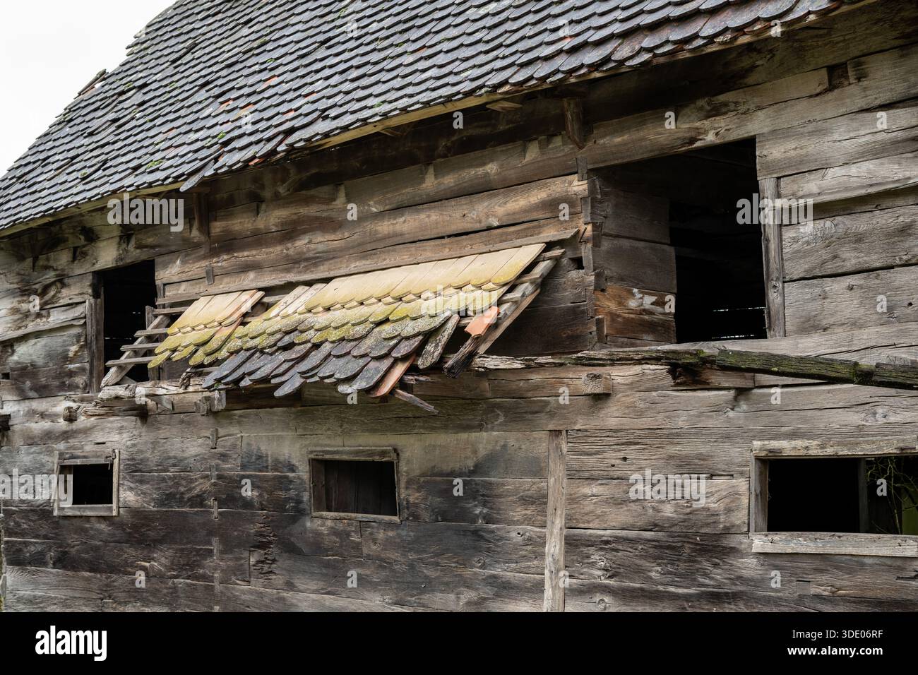 Weathered wood and decaying tiles tell the story of an abandoned barn ...