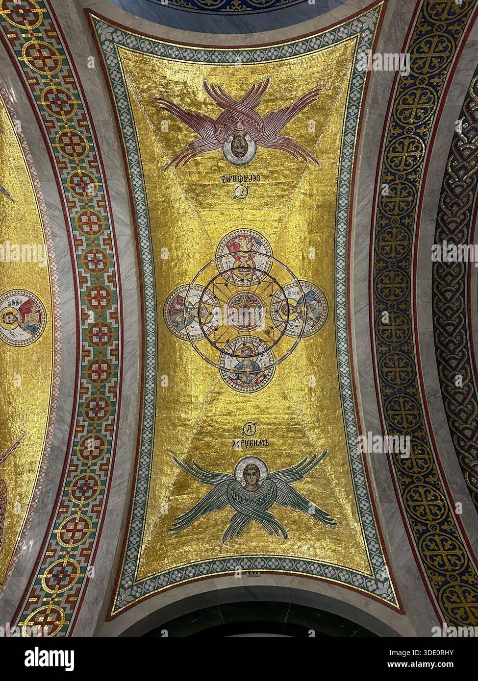 Golden ceiling mosaic depicting angels and sacred symbolism inside the Temple of Saint Sava in Belgrade, Serbia. Monumental Orthodox Christian art. - Smartphone Captured Stock Image