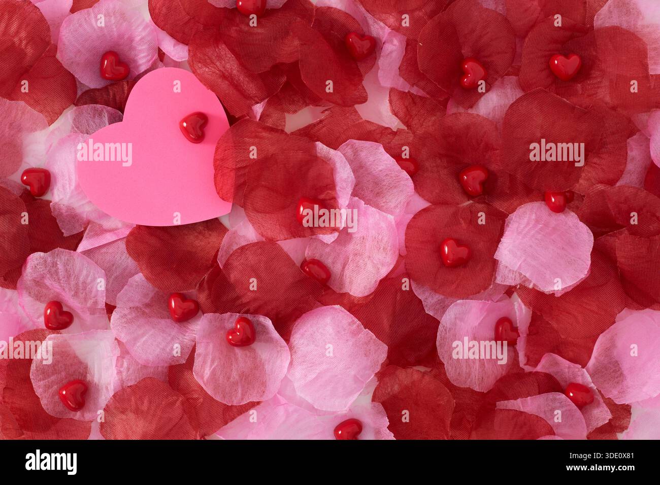 Heart shape sticky notes laying on rose petals Stock Photo