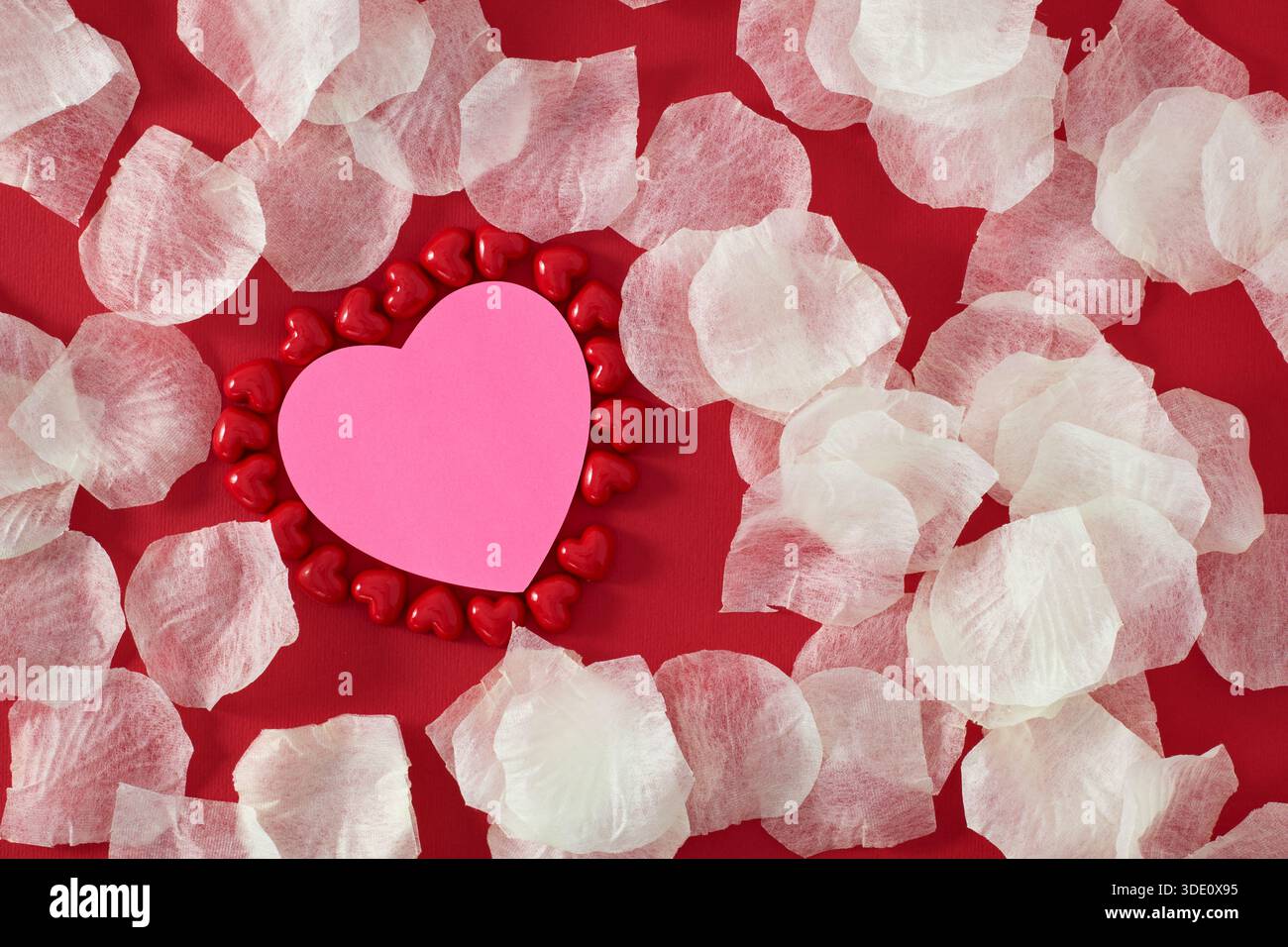 Heart shape sticky notes laying on rose petals Stock Photo