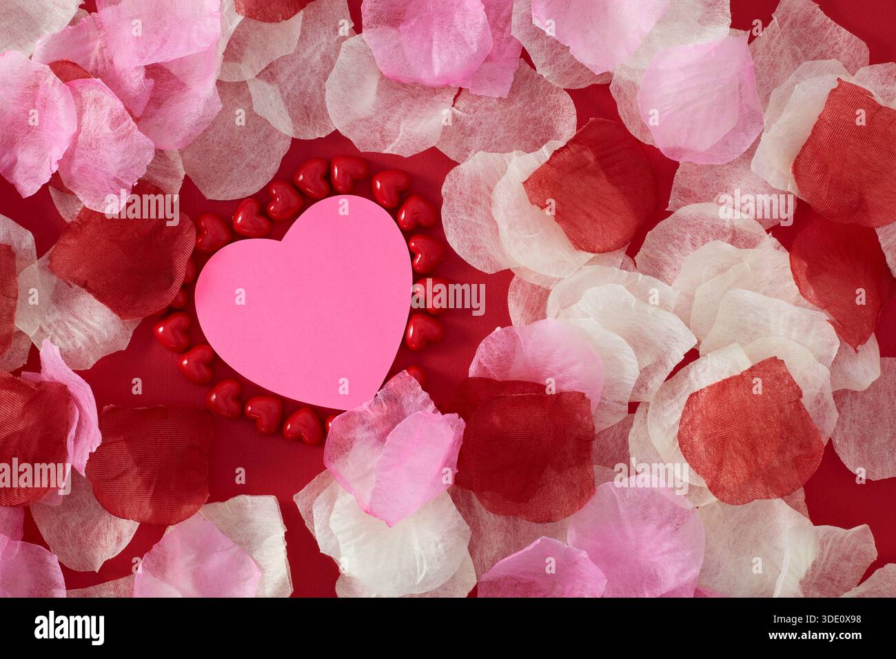 Heart shape sticky notes laying on rose petals Stock Photo