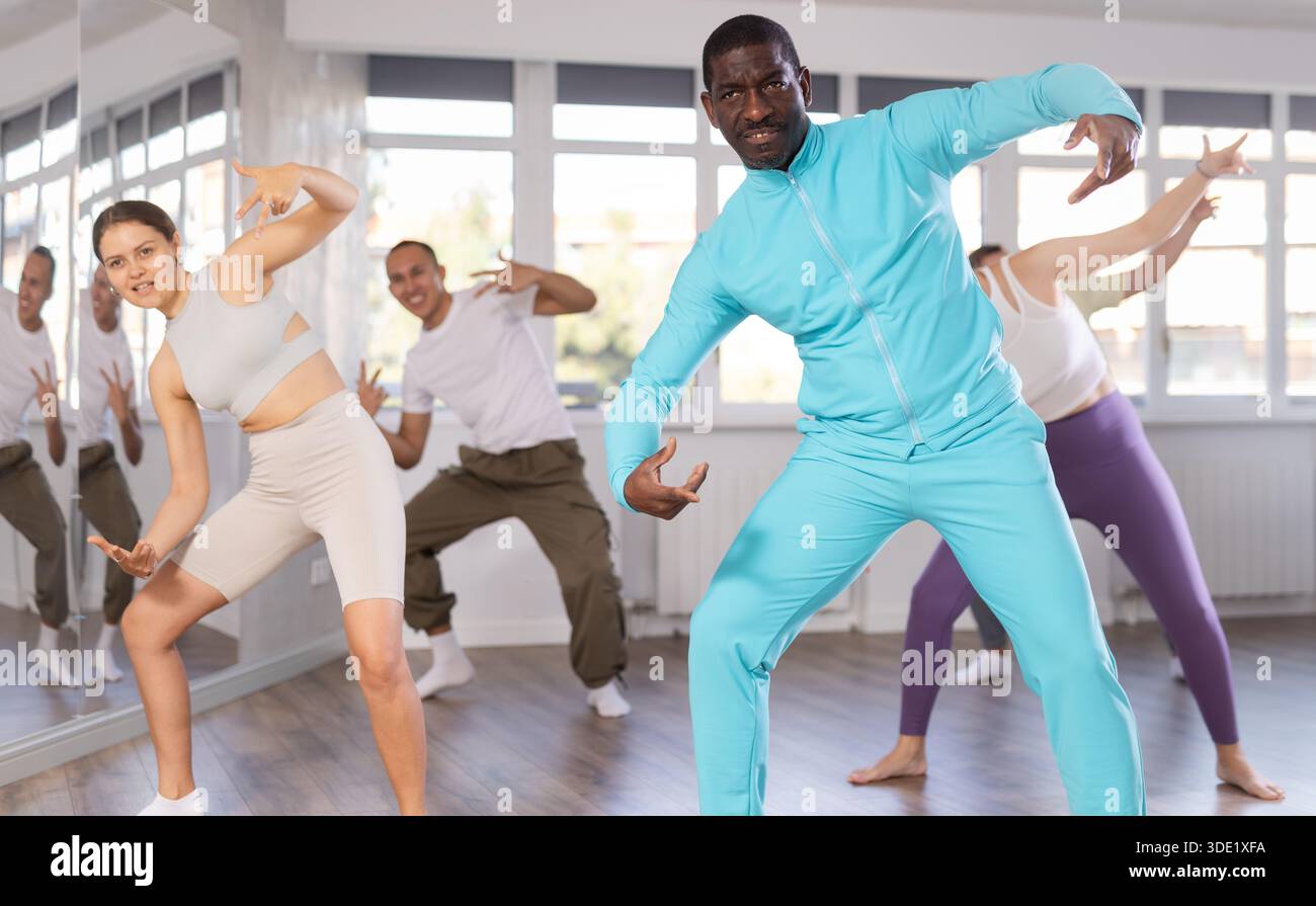 Middle-aged African-American man practicing breakdance in training hall Stock Photo