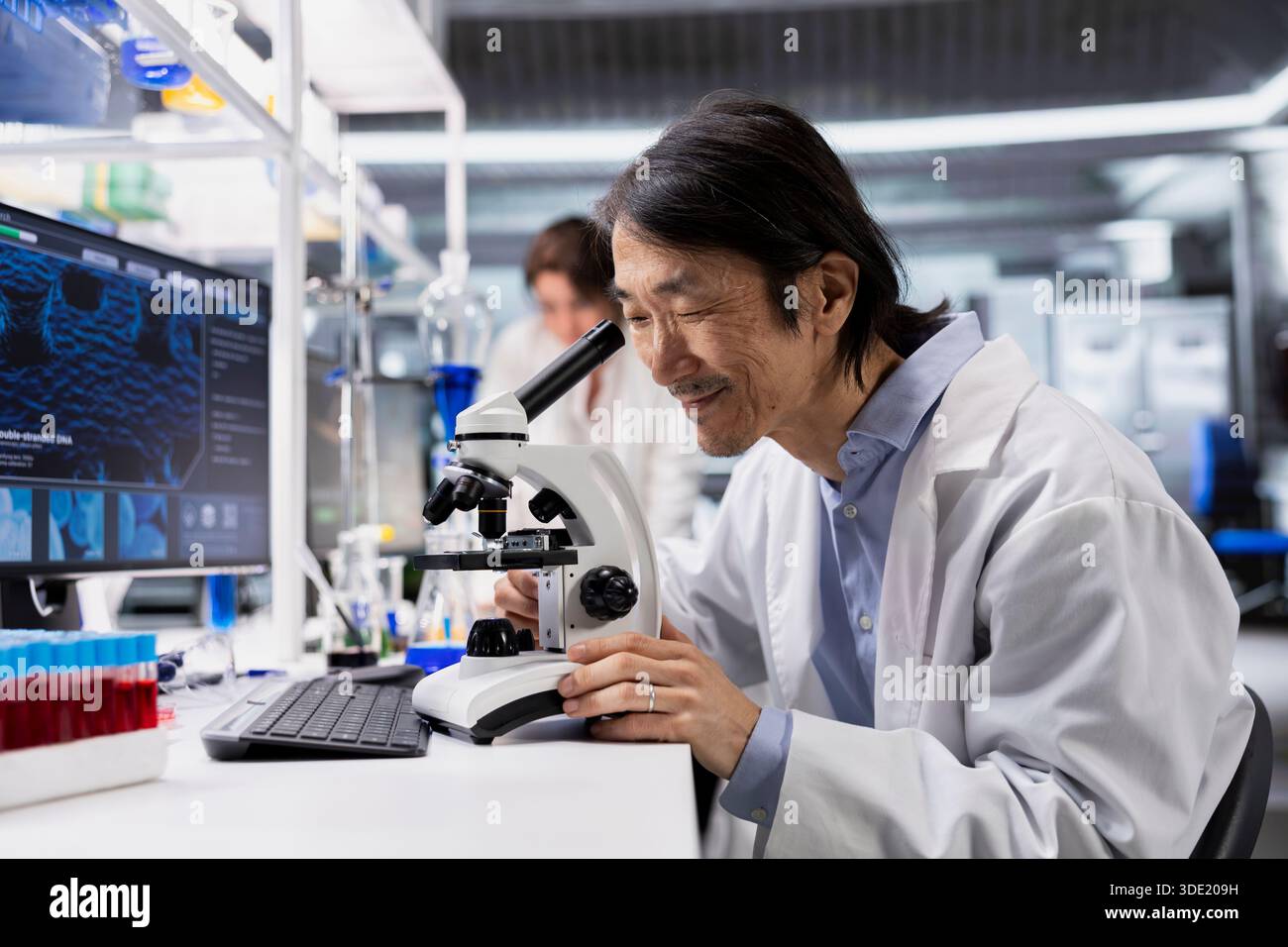 Clinical microbiologist using microscope to evaluate cellular ...