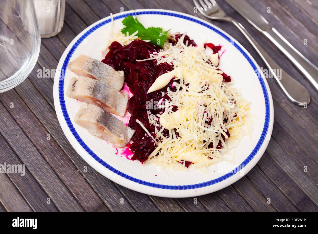 Sliced herring with grated beetroot and cheese served on table Stock Photo