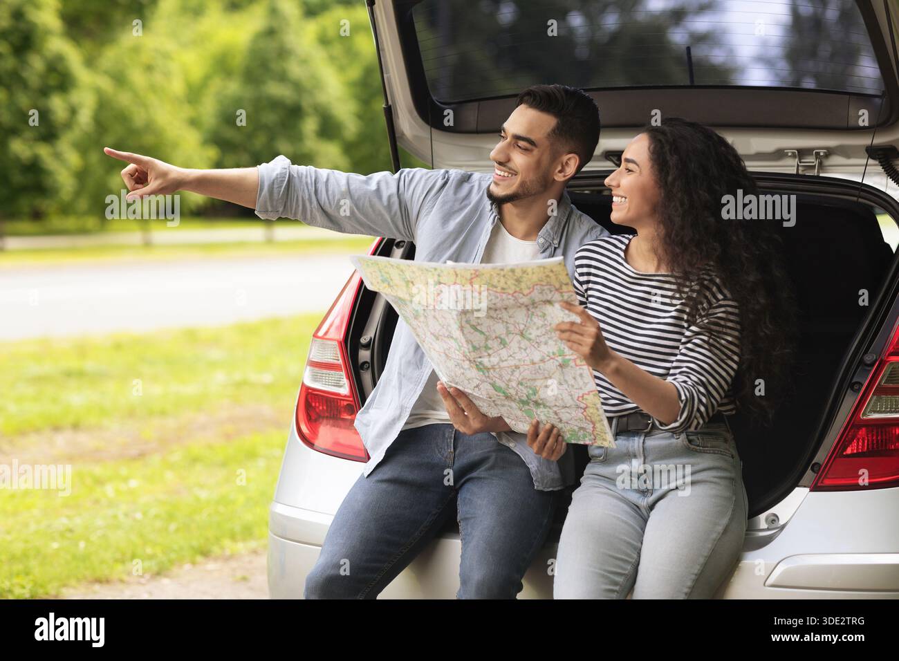 Excited guy traveller showing his girlfriend something aside, copy space Stock Photo