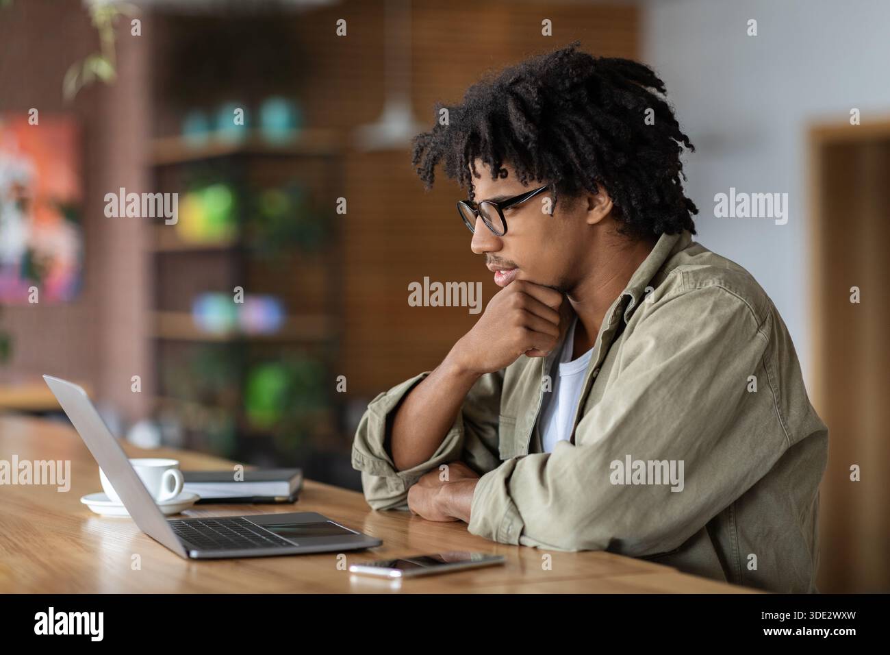 Young Black Male Entrepreneur Working With Laptop At Modern Coffeeshop Stock Photo