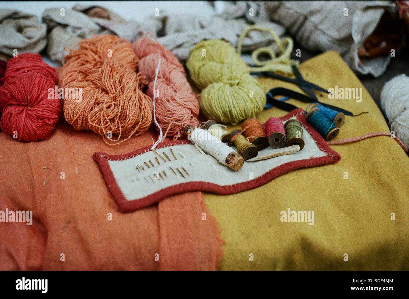 Needles with colored threads and yarns Stock Photo