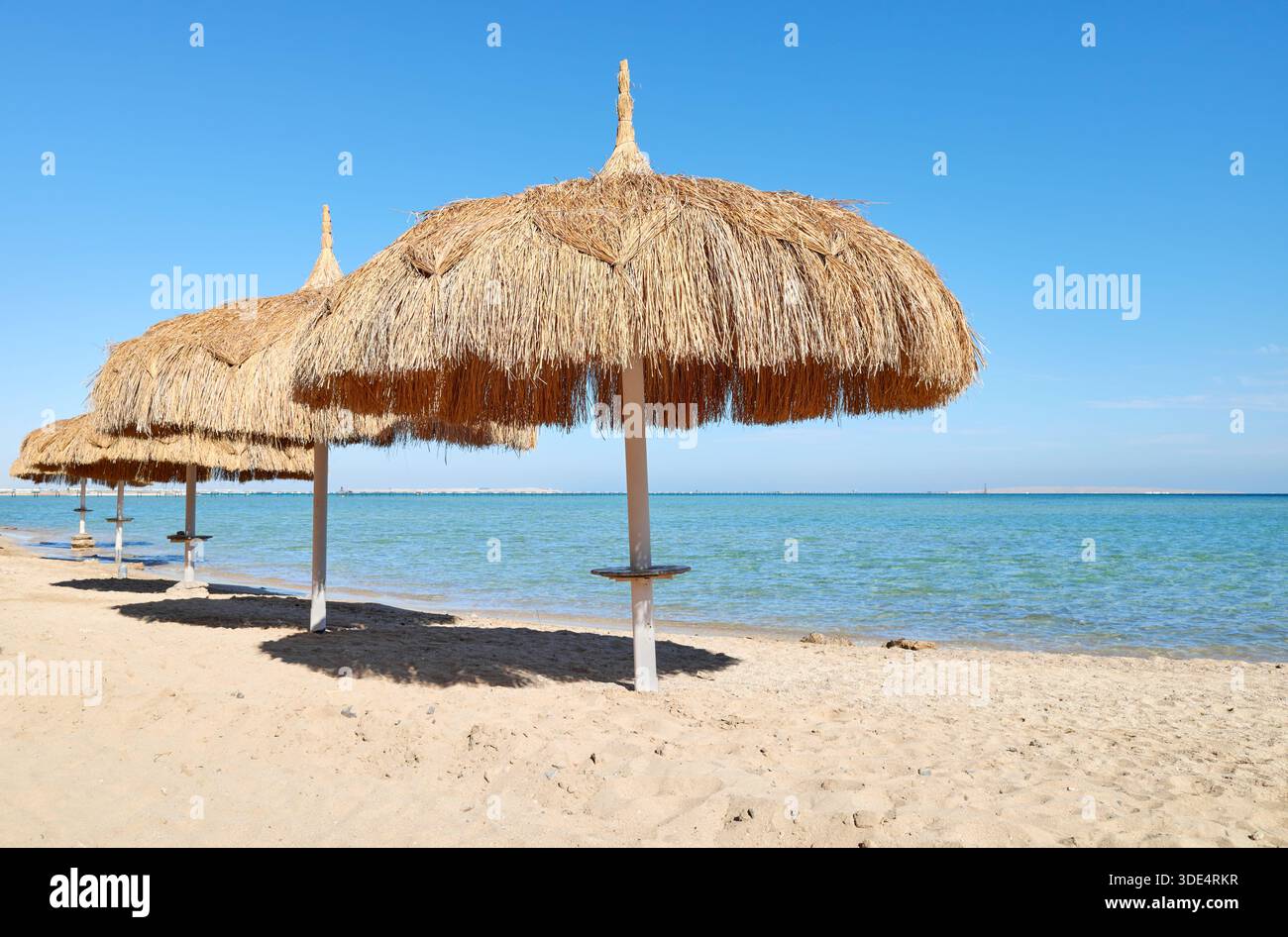 Straw umbrellas on the beach in Hurghada, Egypt. Stock Photo