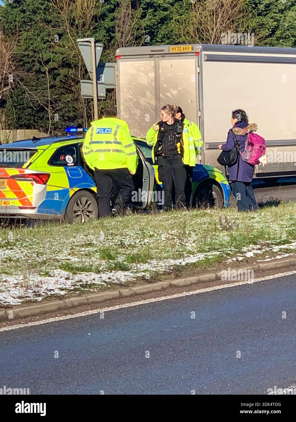 Police officers attend a traffic incident involving a white van and silver ar near a junction in snowy conditions on the A43 in Northampton Northants - Smartphone Captured Stock Image