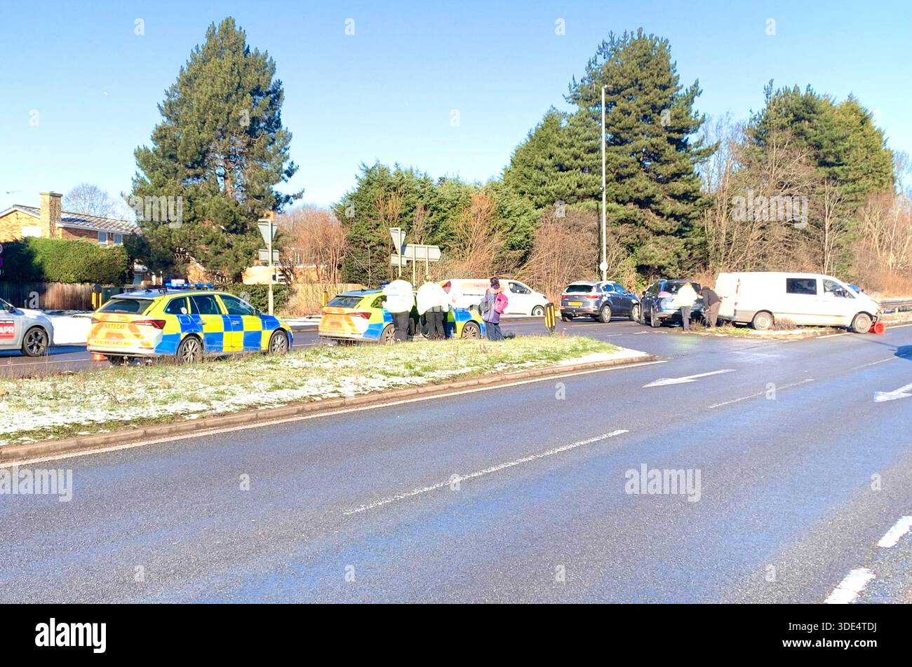 Police officers attend a traffic incident involving a white van and silver ar near a junction in snowy conditions on the A43 in Northampton Northants - Smartphone Captured Stock Image