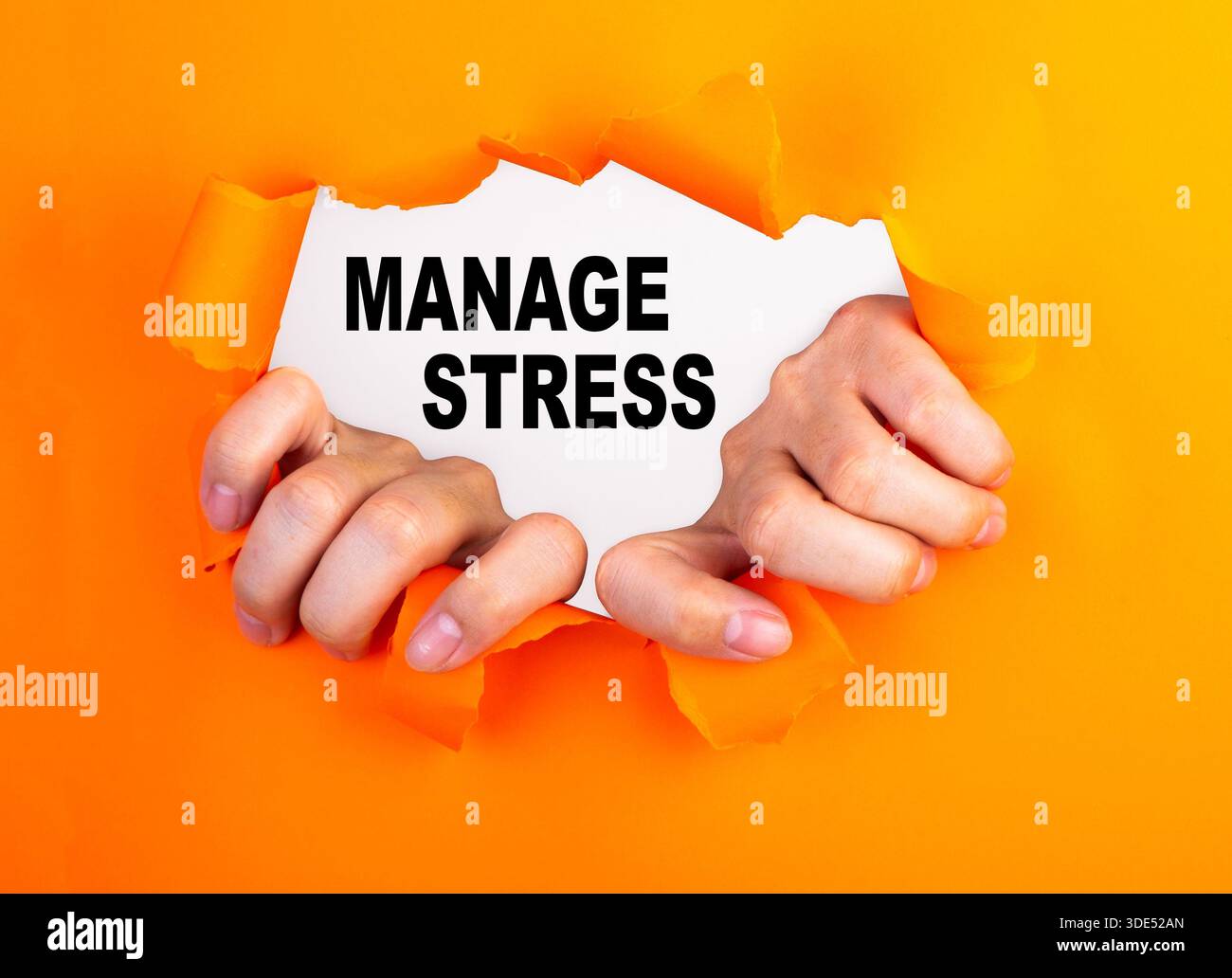 Hands ripping orange paper revealing manage stress text on white ...