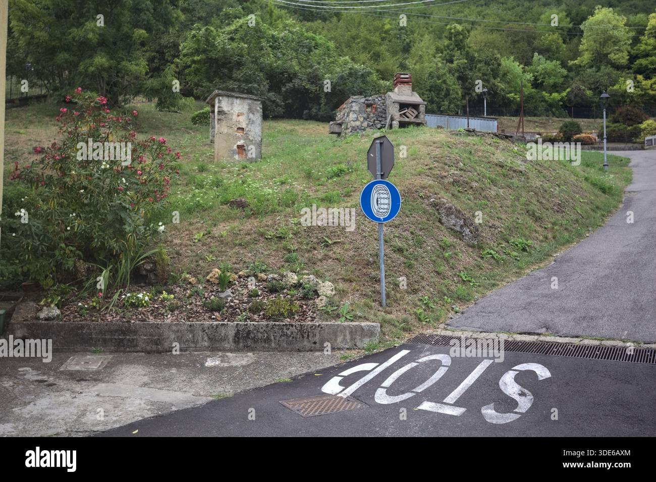 Stop sign on a descending road in the mountain Stock Photo