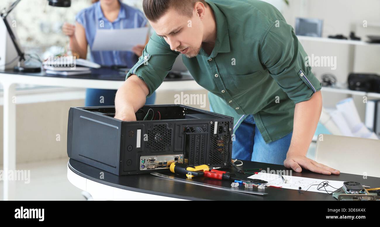 Electronic technician repairing computer in service center Stock Photo
