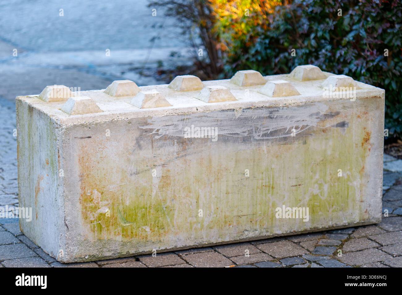 Concrete block shaped like a lego brick acting as an urban barrier ...