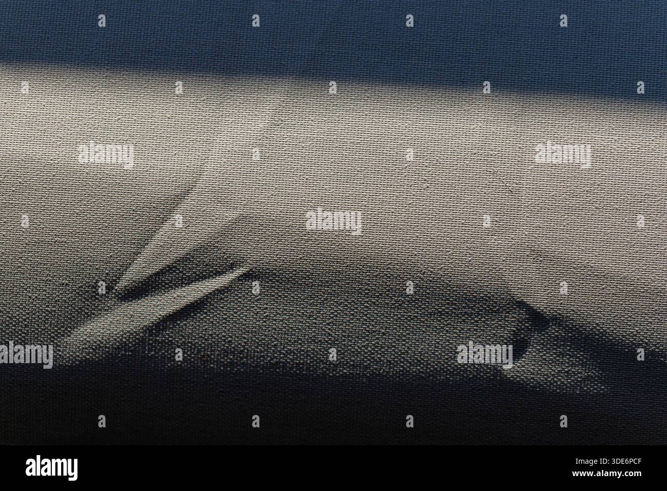 Grey textile surface highlighting abstract shadows and interwoven texture Stock Photo