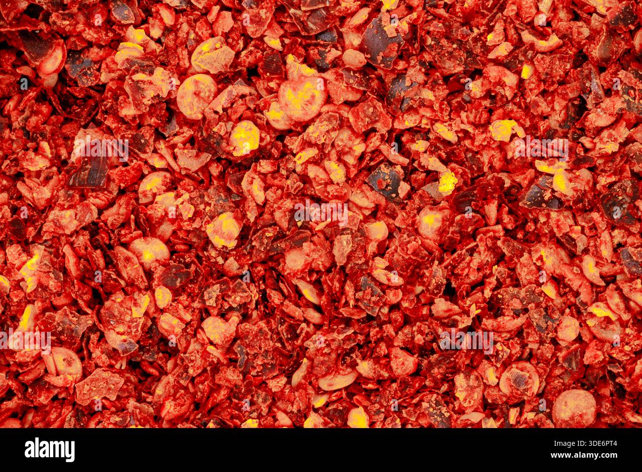 Crushed red pepper flakes creating a vibrant texture and spicy food ingredient background Stock Photo