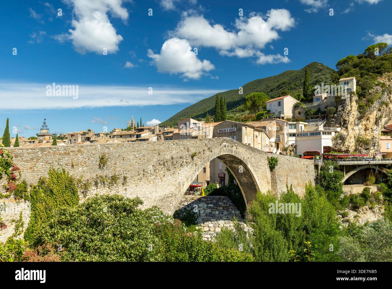 Ancient stone Roman bridge connecting parts of Vaison la Romaine under a blue sky Stock Photo