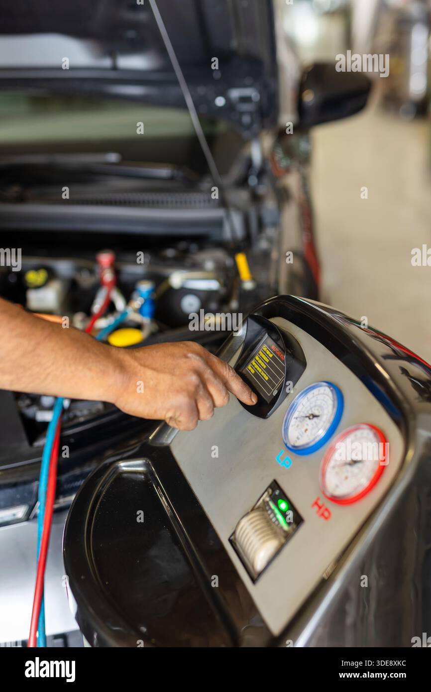 Mechanic checking the car air conditioning system using a technological diagnostic device. Stock Photo