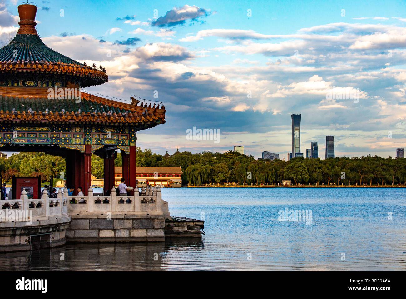 Traditional Chinese pavilion architecture in Beihai Park overlooking the lake in Beijing, China, with the modern Beijing CBD skyline in the distance. Stock Photo