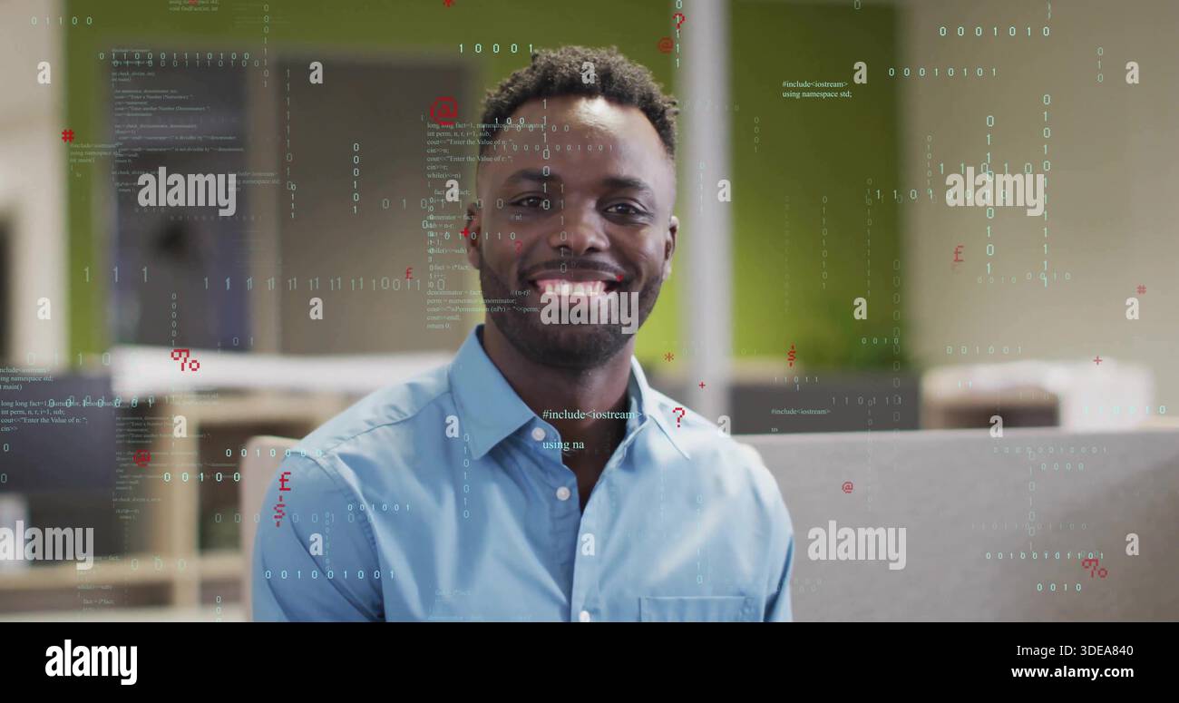 Smiling man in blue button-down shirt posing in open-plan office, with code overlays and cubicles Stock Photo