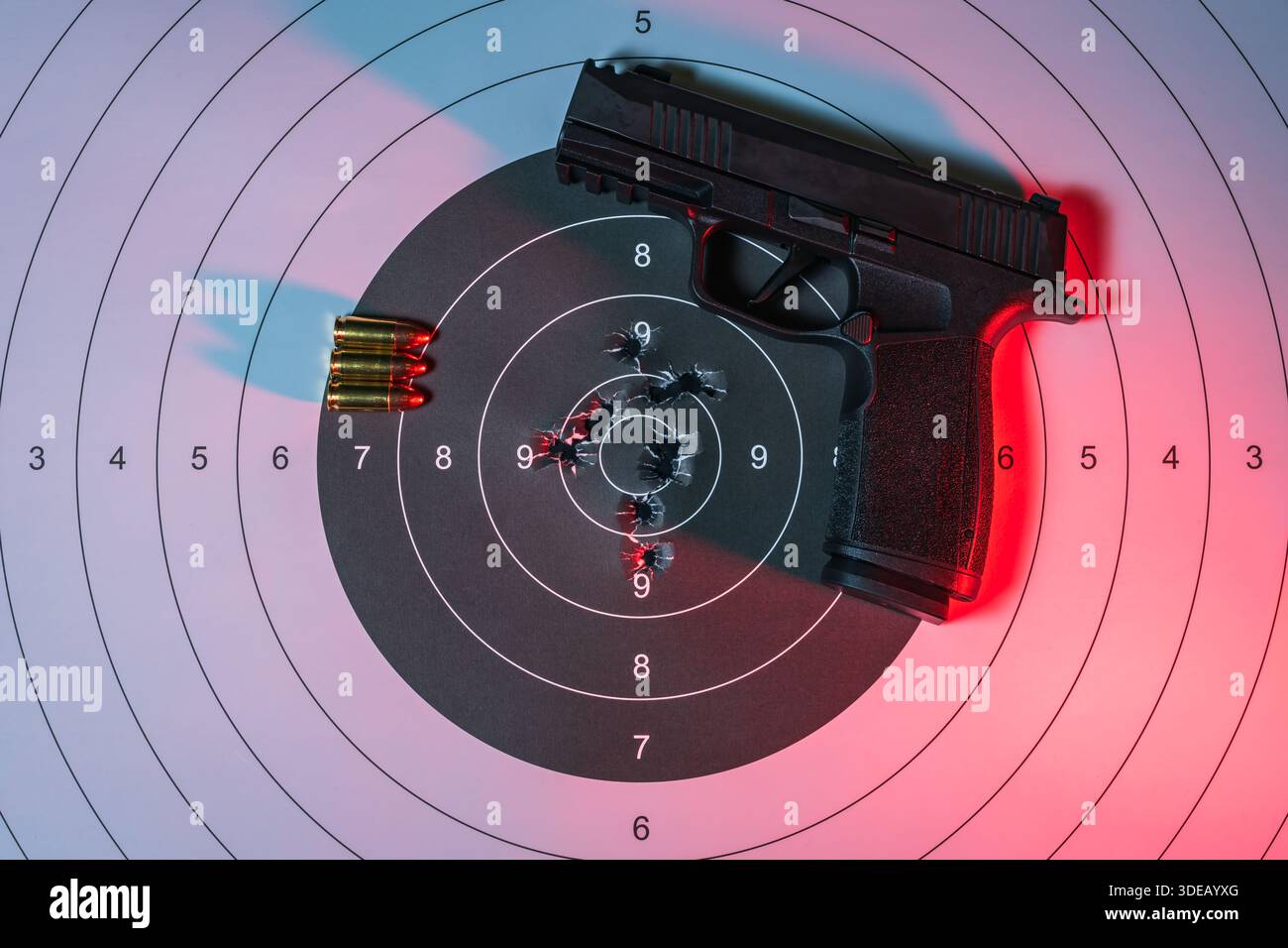 Black modern handgun with bullets on a paper target with bullet holes ...