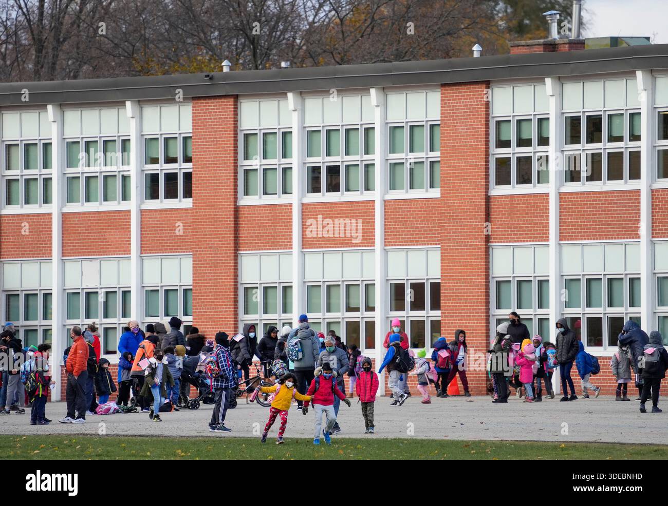 Parents pick up their children as they are dismissed from a school in ...
