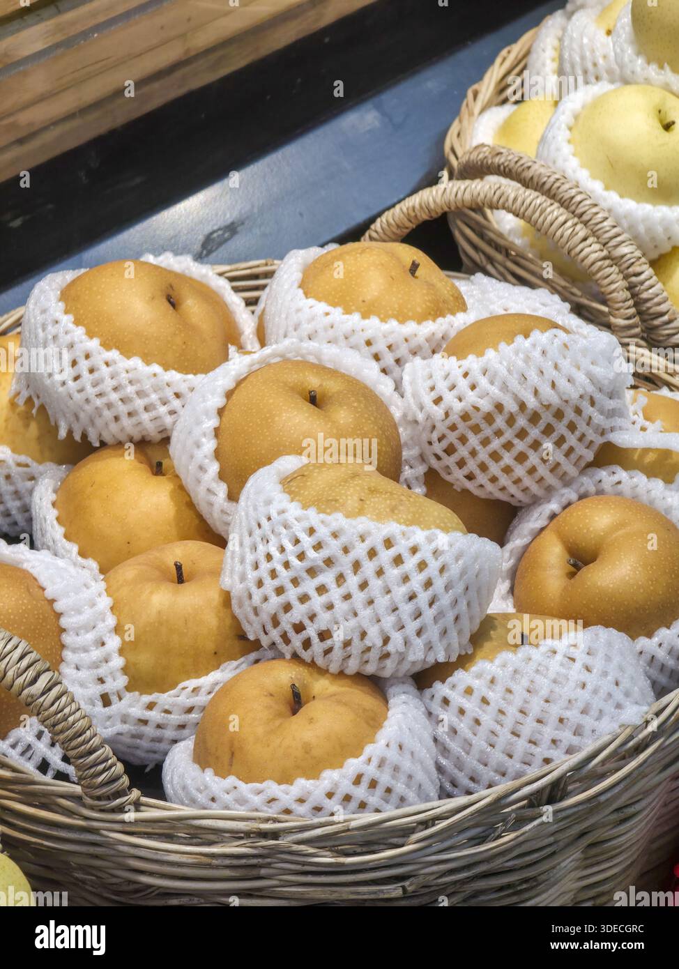 Fresh juicy yellow asian pear piled inside wicker basket protected