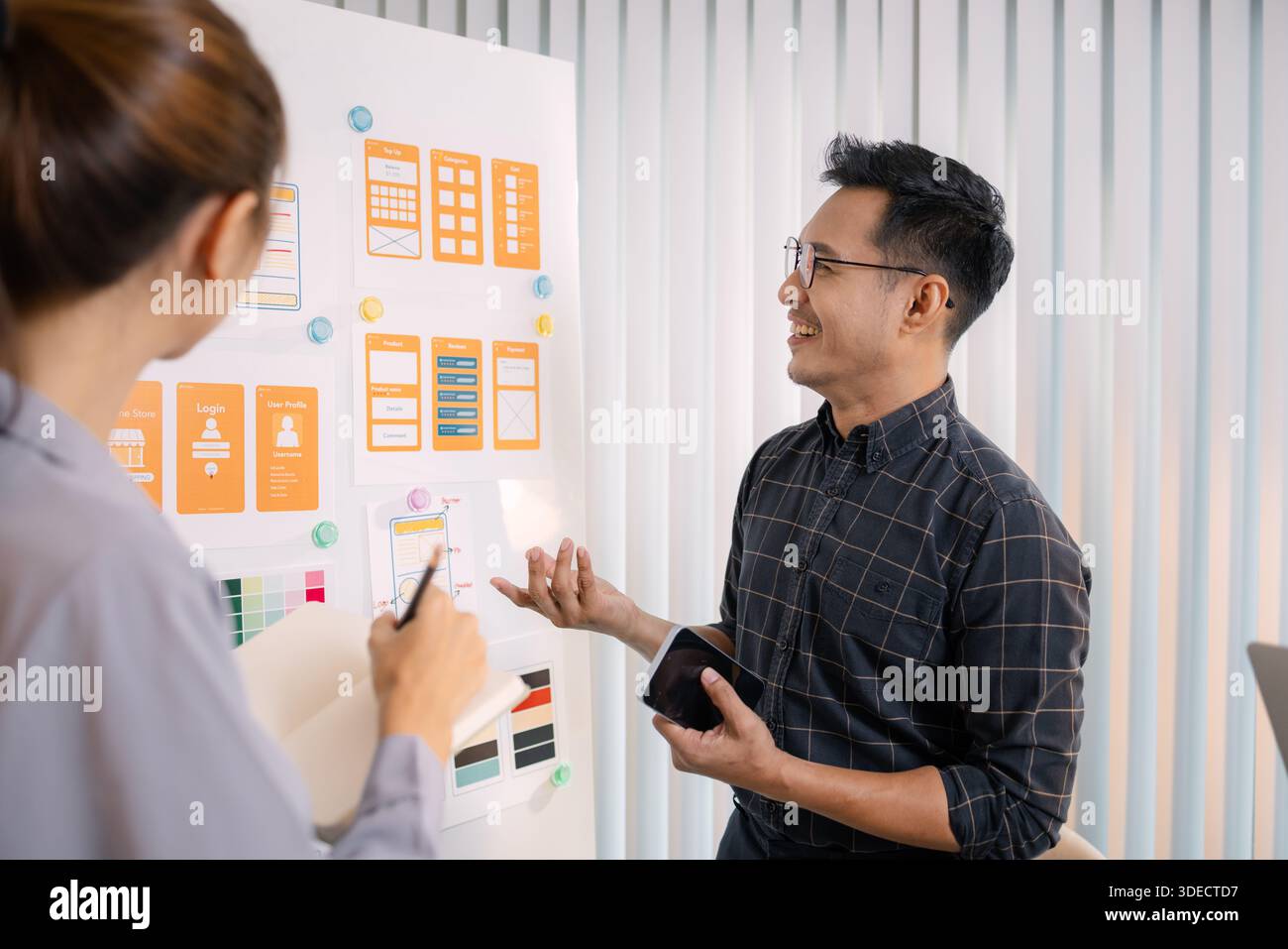 UX/UI designers collaborating during a creative workshop to test interface ideas and exchange feedback for app development, emphasizing teamwork and i Stock Photo