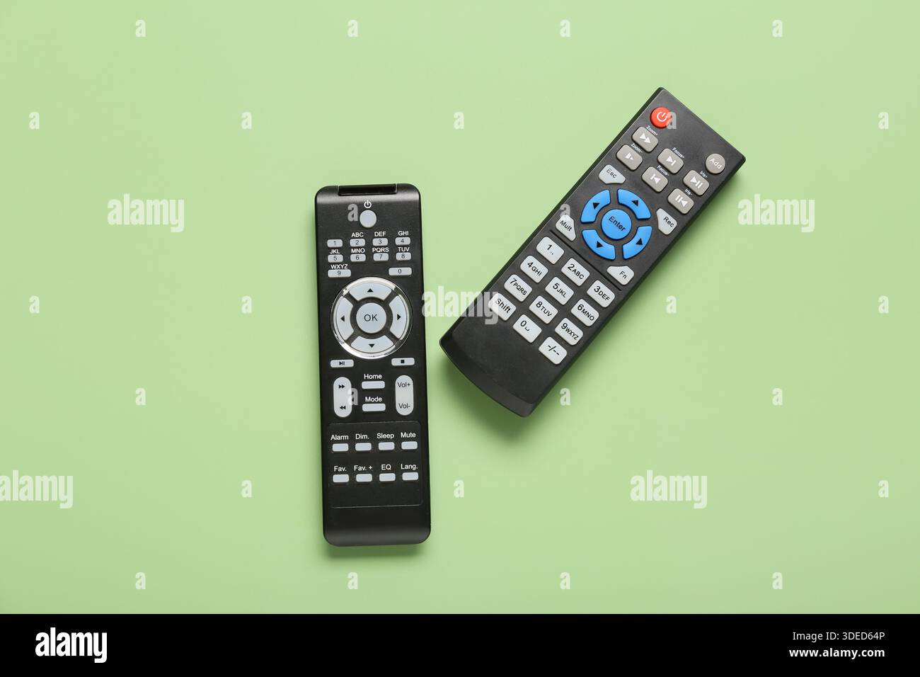 Different modern TV remote controls on green background Stock Photo