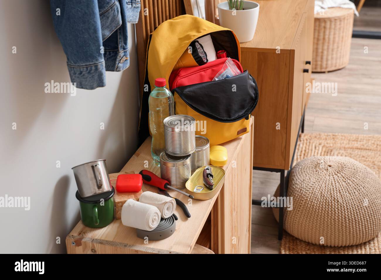 Emergency backpack with necessities on shelf in hallway Stock Photo