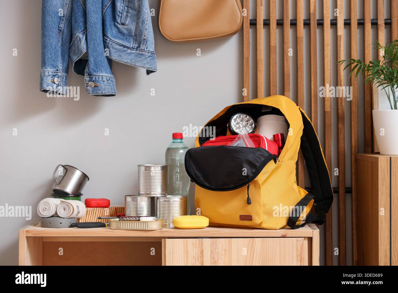 Emergency backpack with necessities on shelf in hallway Stock Photo