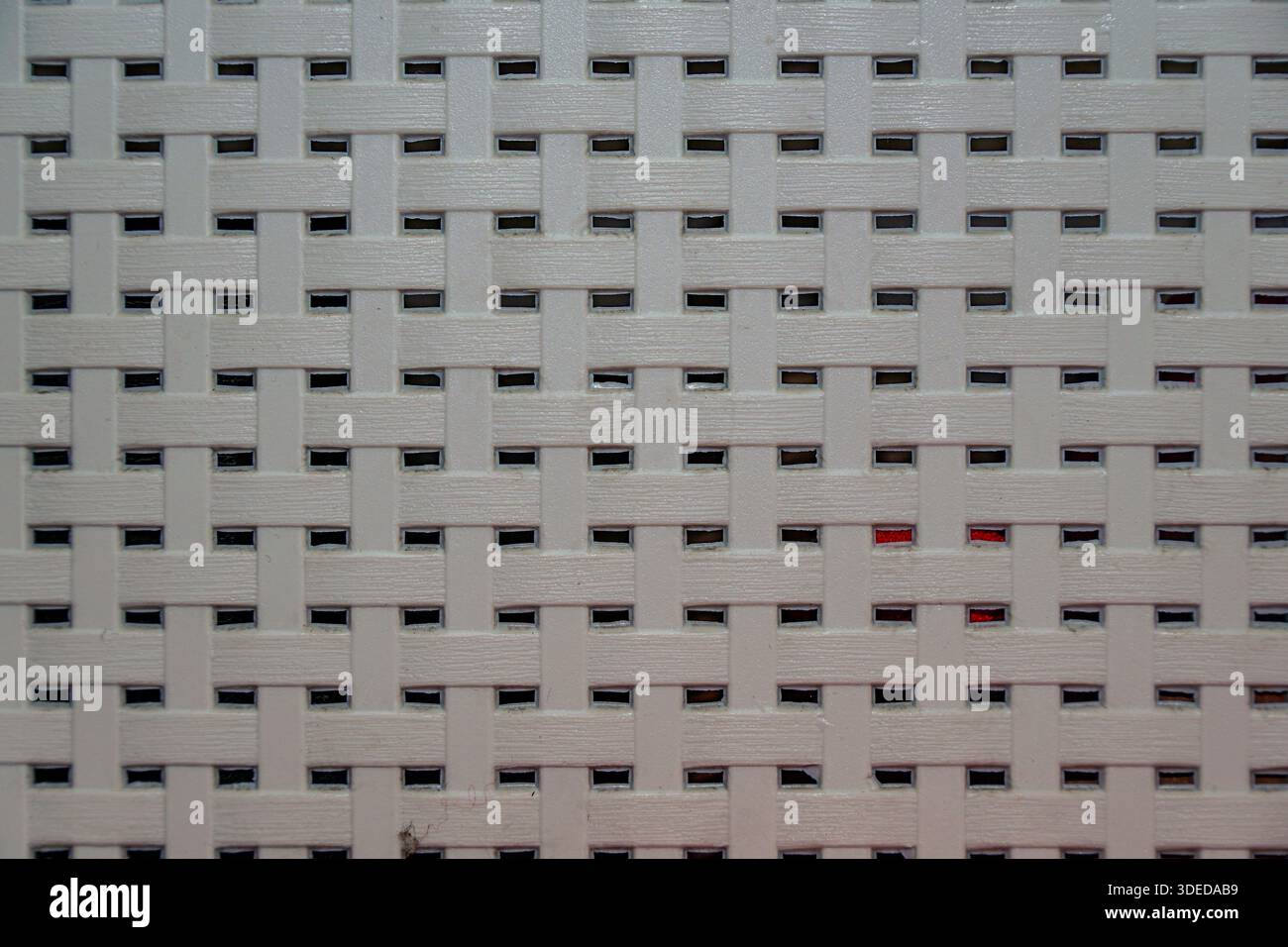 White synthetic woven material texture background with a repetitive grid pattern and small rectangular openings. Stock Photo