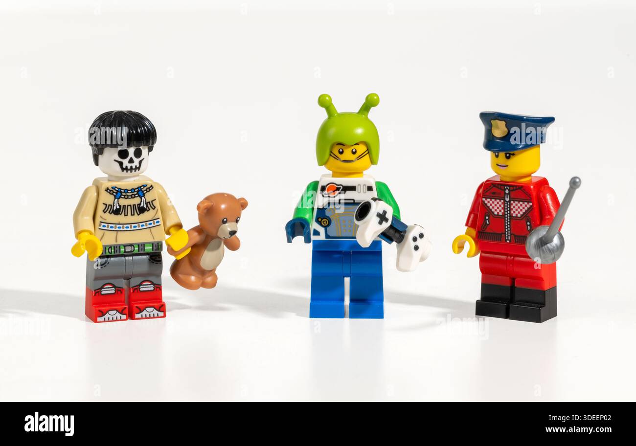 Lego skeleton, alien and police officer minifigures standing on white background, representing diversity and inclusion Stock Photo