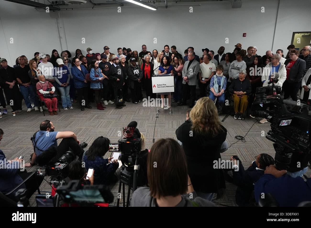 A crowd gathers behind a speaker during an event for survivors on the ...