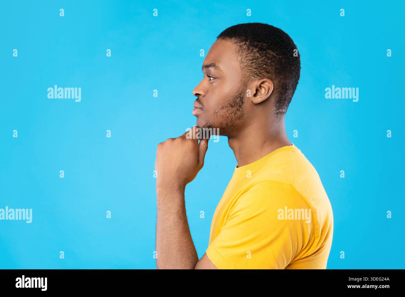 Side View Portrait Of Thoughtful Black Guy On Blue Background Stock Photo