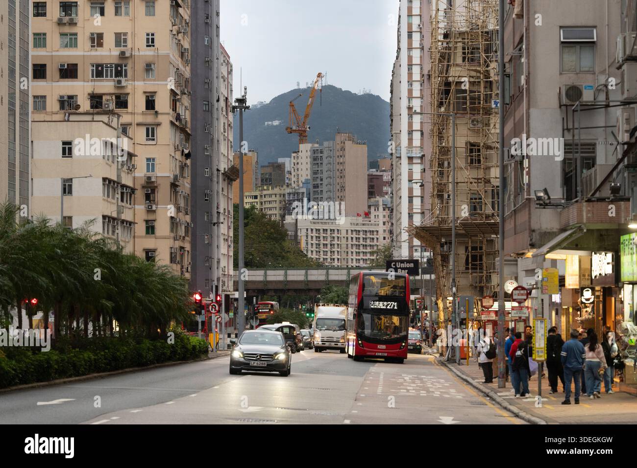Kowloon, Hong Kong, passes by buildings and a mountain. Stock Photo