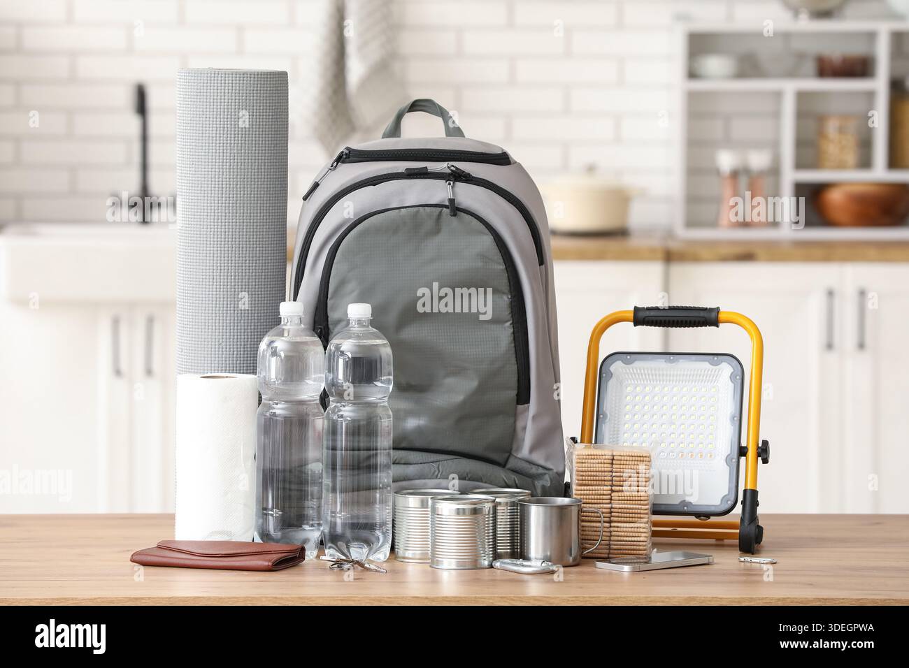 Emergency backpack with necessities on table in kitchen Stock Photo
