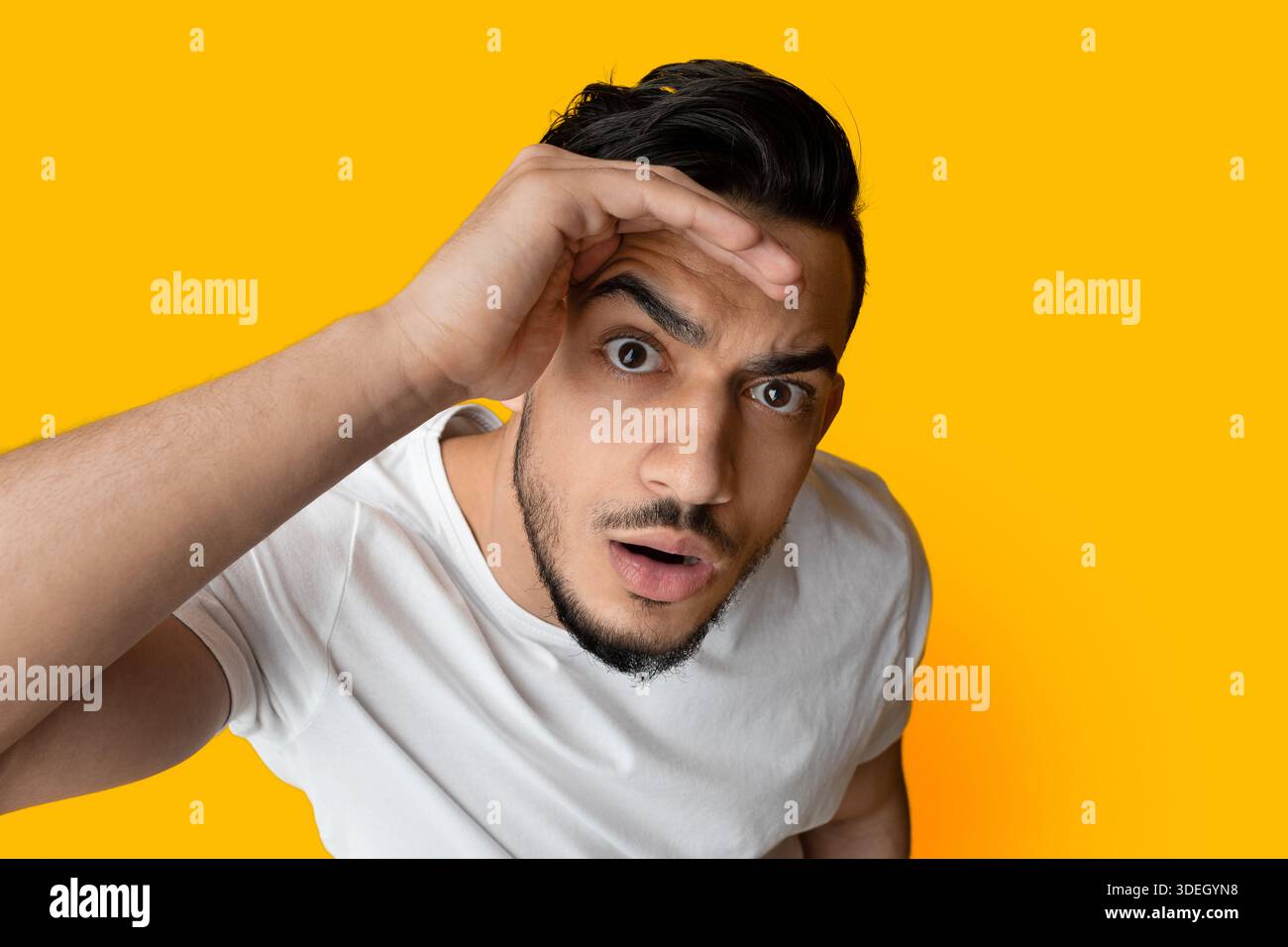 Top view of surprised middle eastern guy looking at camera Stock Photo