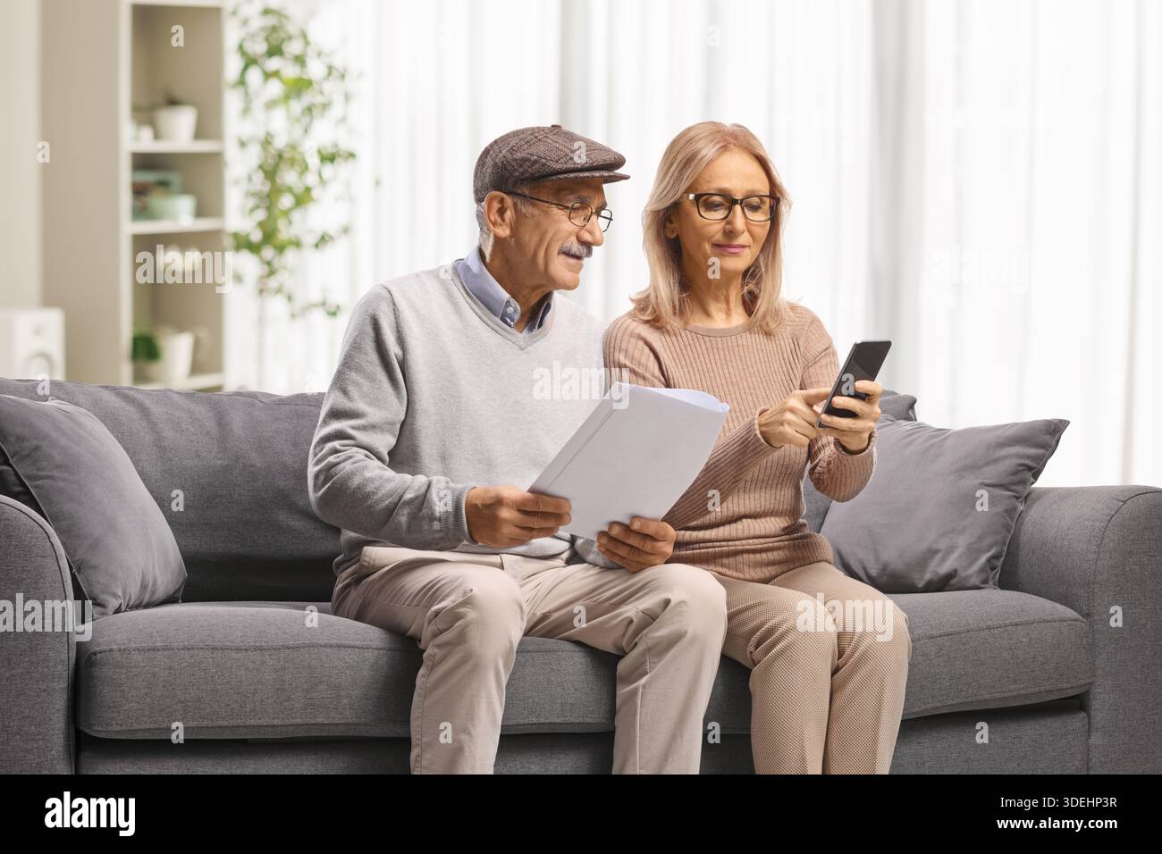 Mature couple reading documents on a sofa Stock Photo
