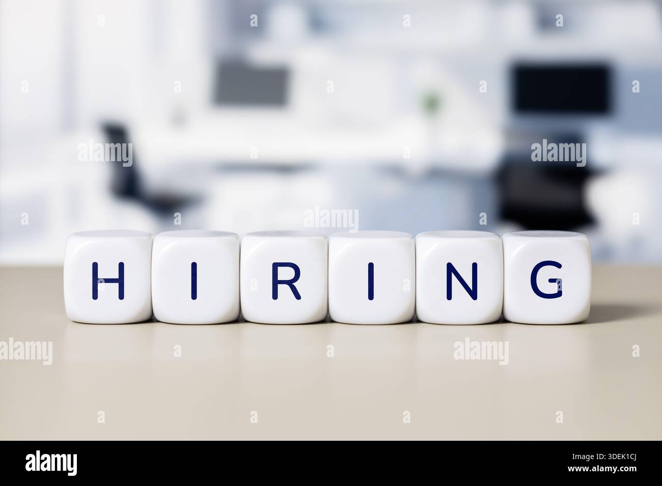 Hiring word cubes representing recruitment in office setting Stock Photo