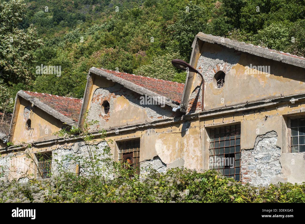 Old obsolete industrial building facade with broken windows Stock Photo